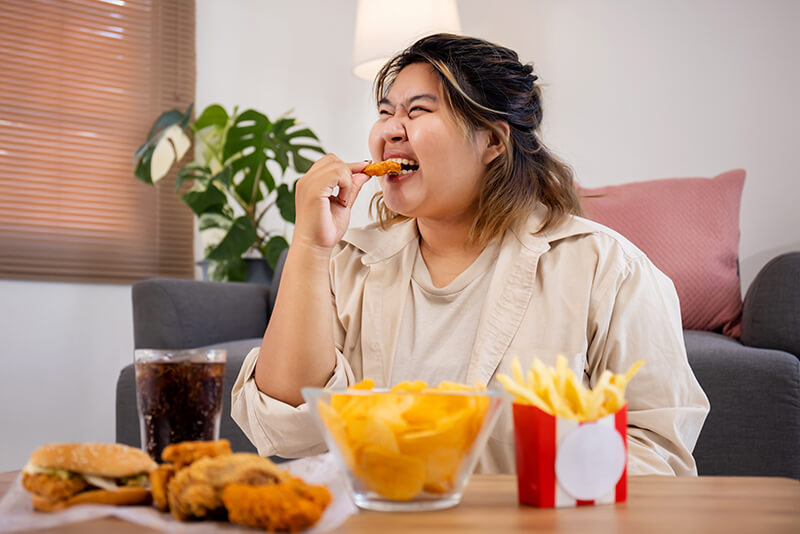 happy asian fat woman enjoy eating delicious fried chicken living room (1)